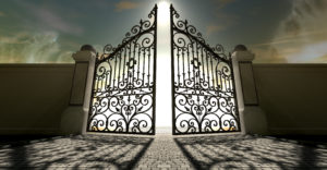 A set of ornate gates to heaven opening under an ethereal light and cloudy afterlife